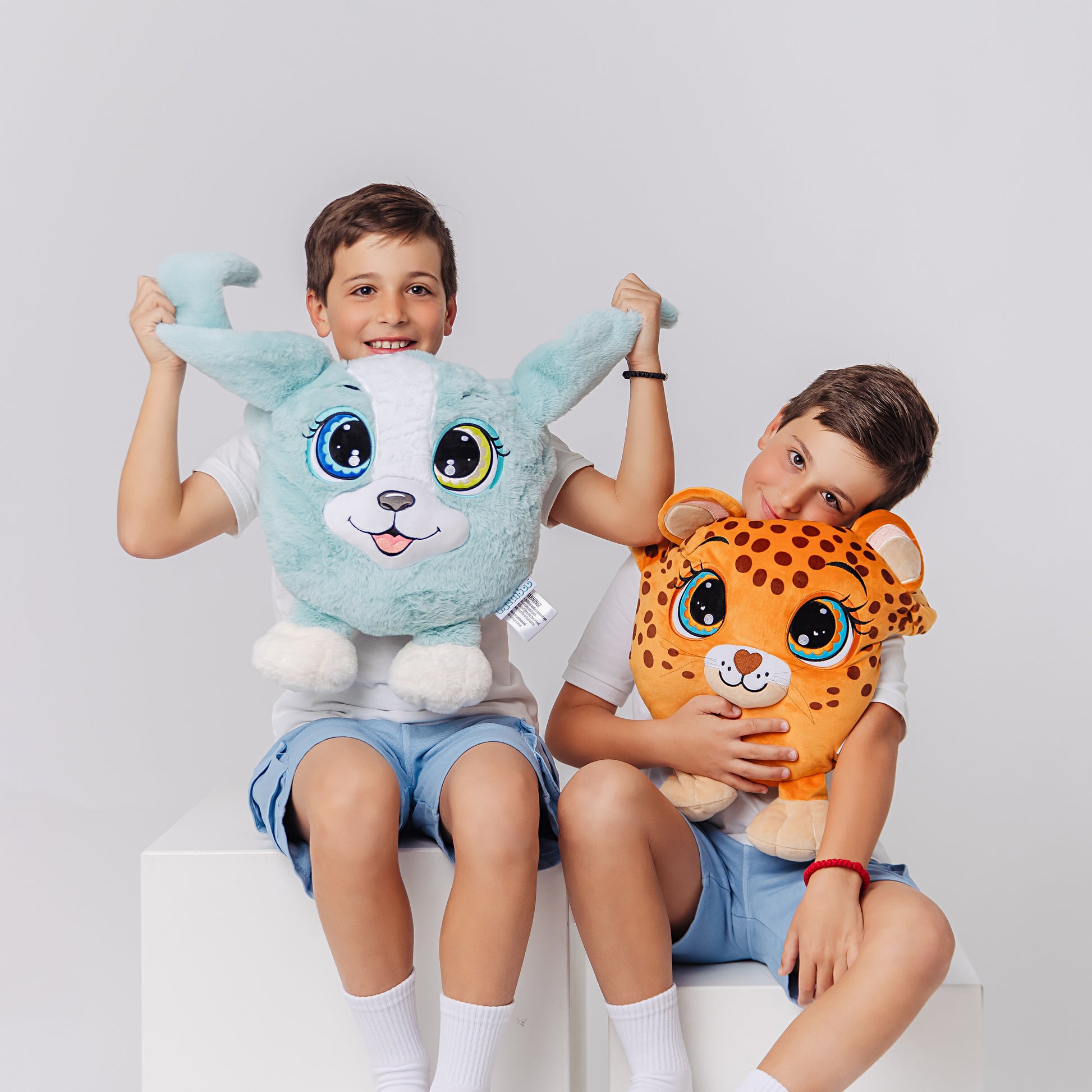 Two children enjoying a plush weighted leopard and puppy, each featuring large expressive eyes, 3D sensory cheeks, paws, and nose. These super-soft, cuddly sensory plushies are perfect for comfort, relaxation, and stress relief, showcased on a clean white background.