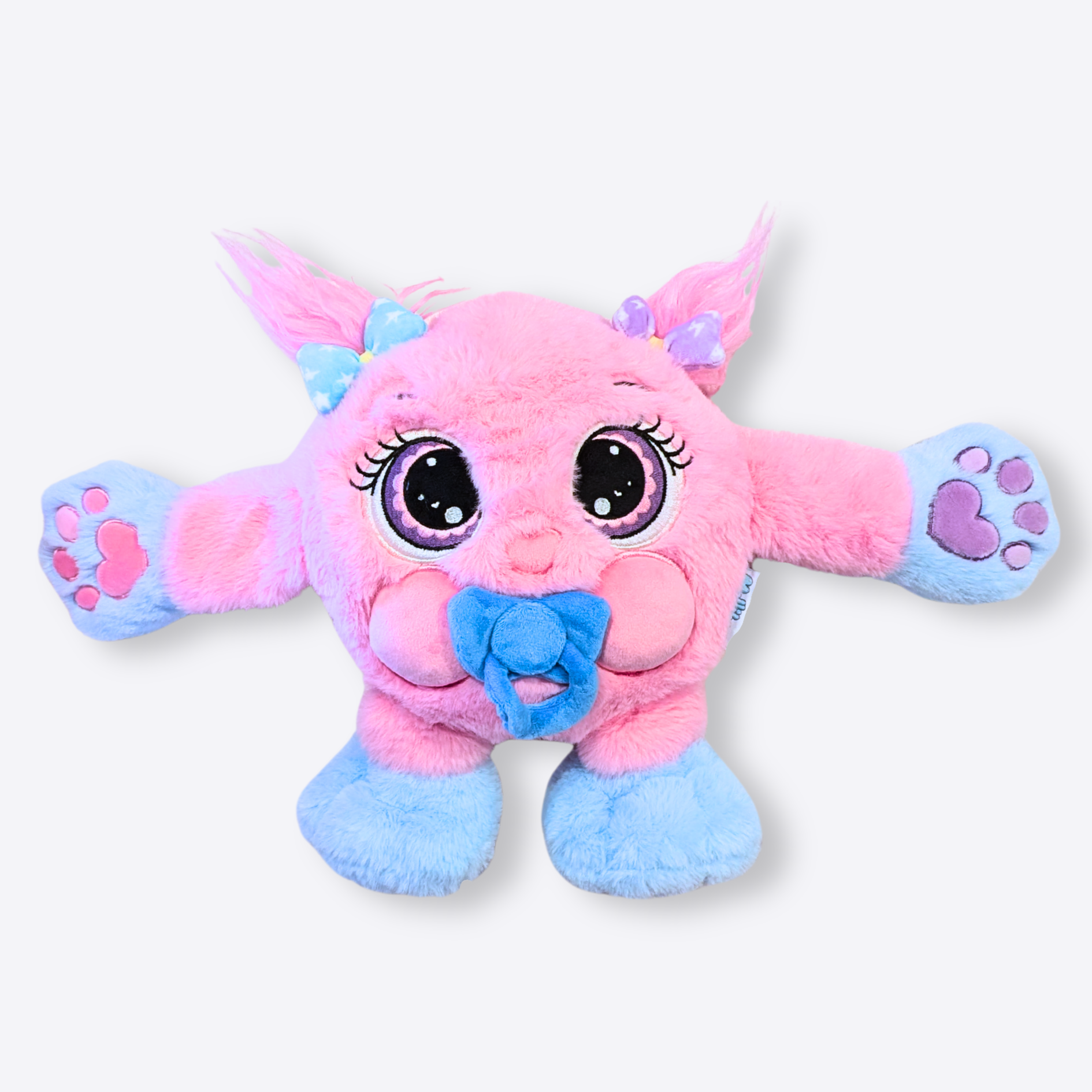 A pink and blue plush weighted toy featuring 3D sensory cheeks, paws, and nose, with large eyes set against a white background.