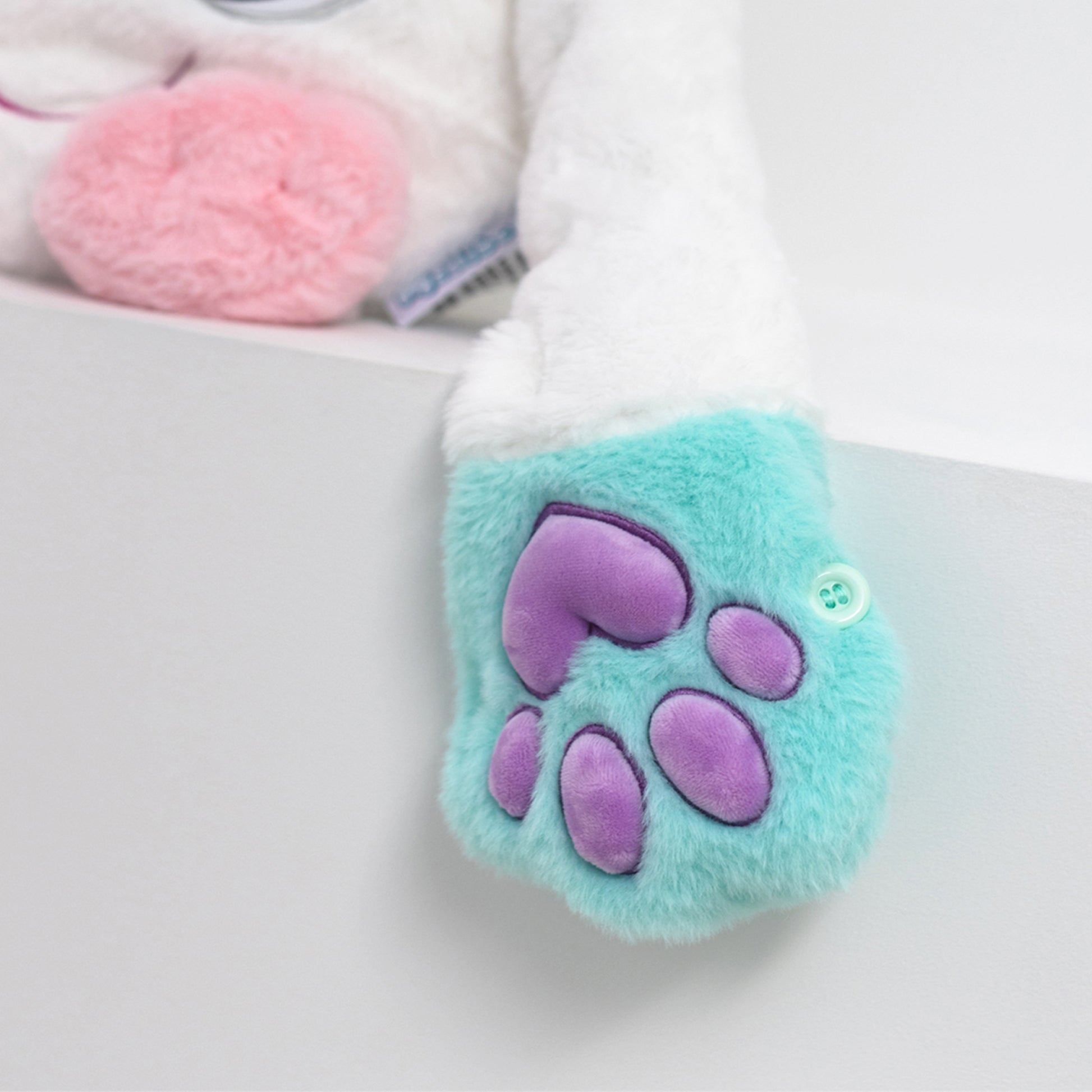 Plush toy with a 3D paw print design on a light gray background