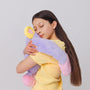 Girl hugging a purple plush weighted toy featuring 3D sensory cheeks, paws, and nose, with pink paws, blue accents, and large expressive eyes. This soft, cuddly sensory plush is perfect for relaxation, stress relief, and comfort, shown on a clean white background.