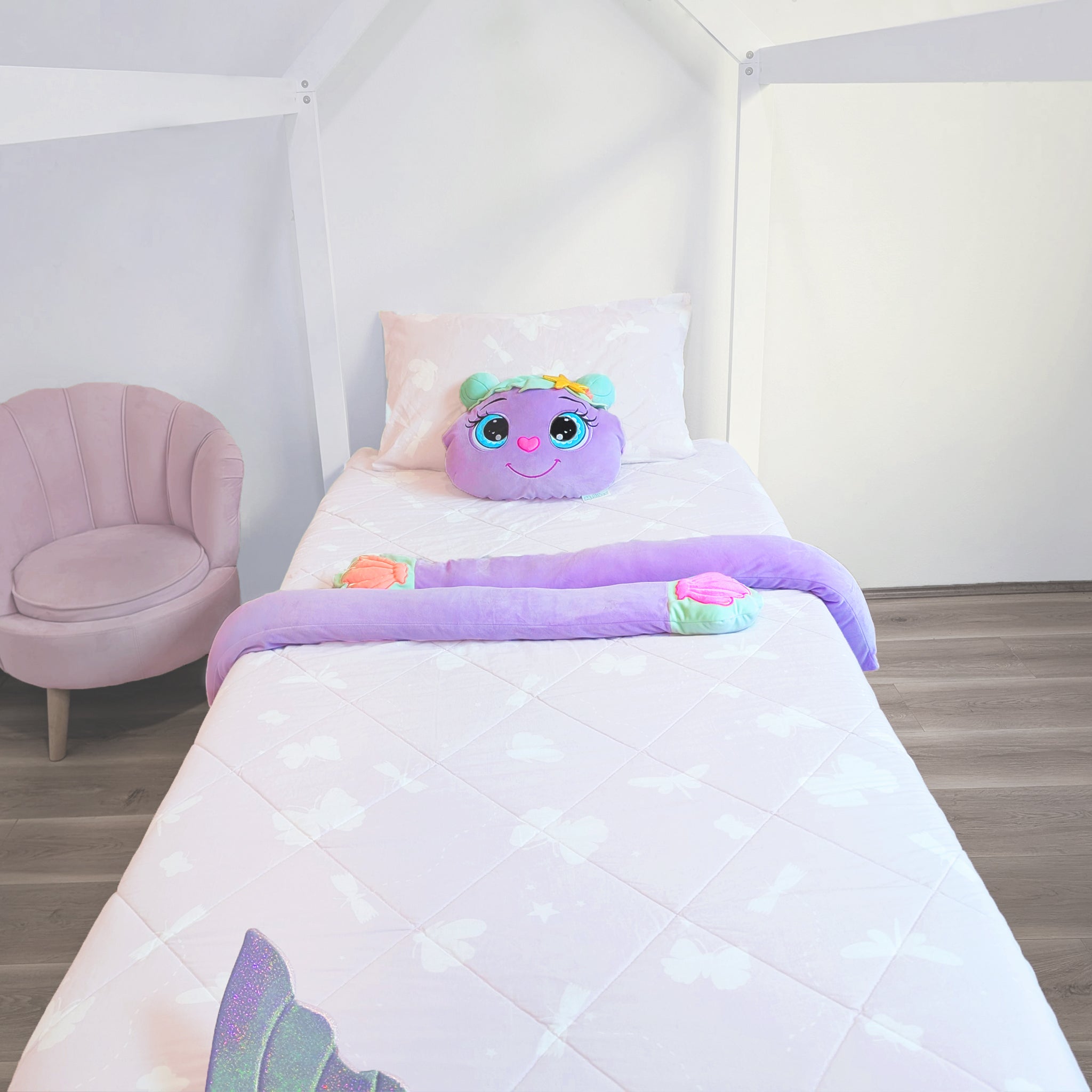 Children's room with a bed featuring a purple plush toy with a smiling face, surrounded by a white canopy.